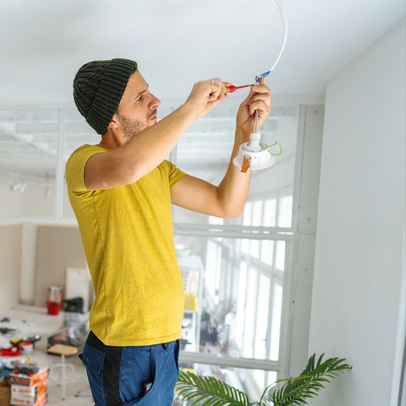 Man installing ceiling light fixture in modern room.