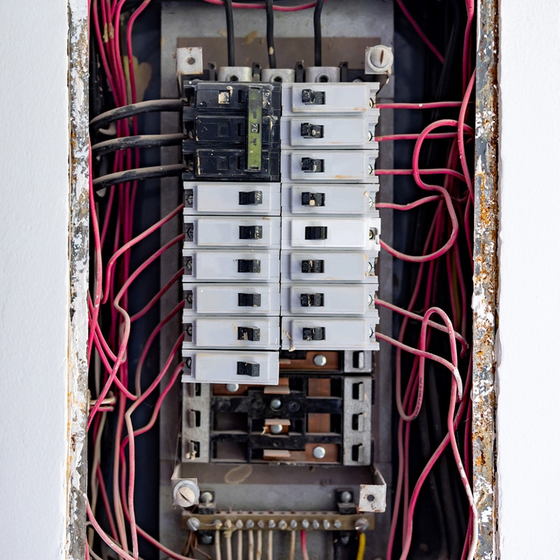 Electrical circuit breaker panel with numerous wires connected for power distribution.